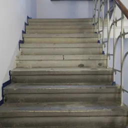 Schody z piaskowca częściowo wyczyszczone z brudu i powłok zabezpieczających.