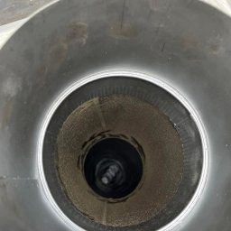 FREZ-STO Frezowanie i renowacja kominów - Wnętrze metalowego przewodu wentylacyjnego z widocznymi zabrudzeniami i osadami, sfotografowane od wewnątrz.