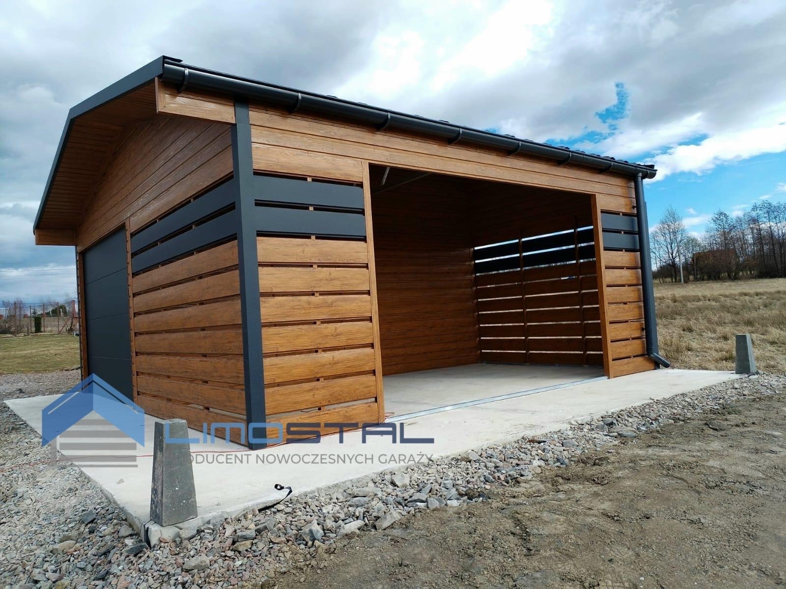 Nowoczesny garaż z drewnianą elewacją i szarą stolarką, z otwartym wjazdem i zamkniętą bramą, na betonowej wylewce z widocznym logo producenta.