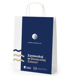Digital Marketing, Branding, Key Visual - Biała torba papierowa z granatowym nadrukiem logo i hasłem 'Zamieszkaj w Słonecznej Zatoce!', widoczna z bliska, z białymi uchwytami sznurkowymi.
