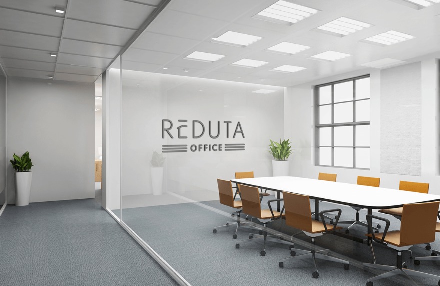 Nowoczesna sala konferencyjna z logo firmy 'Reduta Office' na szklanej ścianie. Biały stół otoczony brązowymi krzesłami, okno z naturalnym światłem.