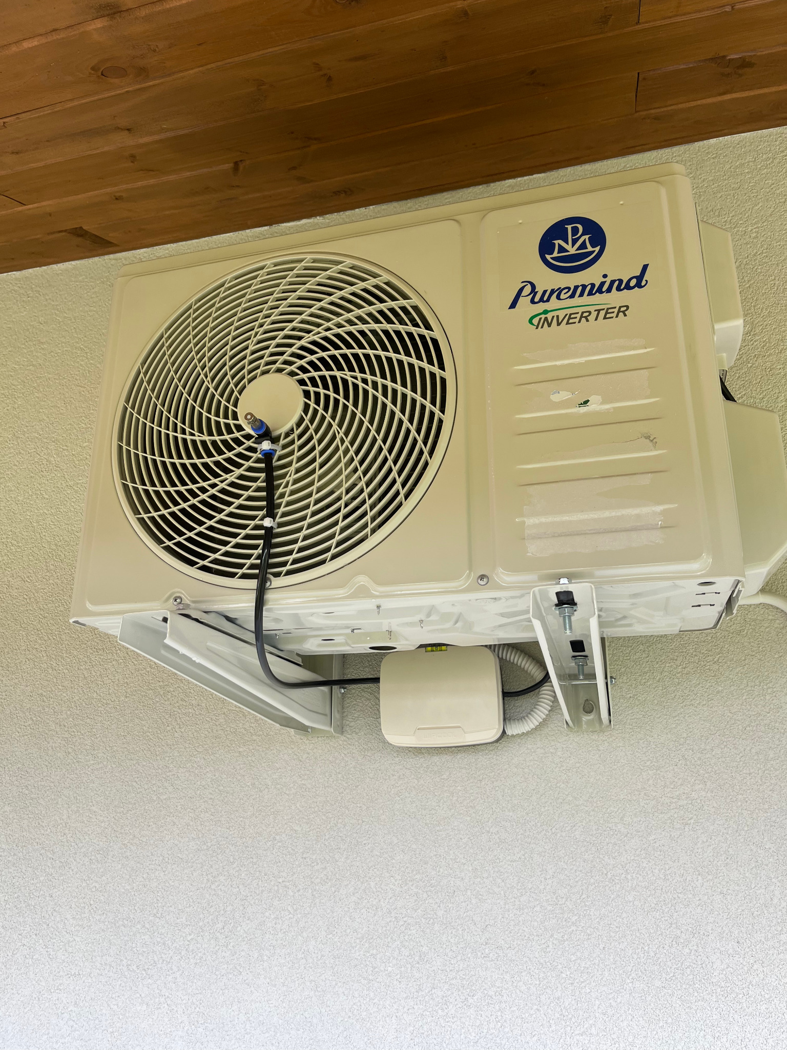 Zamontowana klimatyzacja Puremind Inverter na elewacji budynku, widoczne elementy instalacji i drewniany element konstrukcyjny dachu.