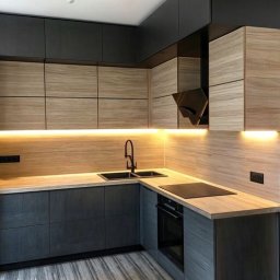 PROGRES SPÓŁKA Z OGRANICZONĄ ODPOWIEDZIALNOŚCIĄ - Nowoczesna kuchnia w odcieniach szarości i beżu z drewnopodobnymi frontami szafek, podświetlanym blatem i czarną armaturą oraz płytą indukcyjną.