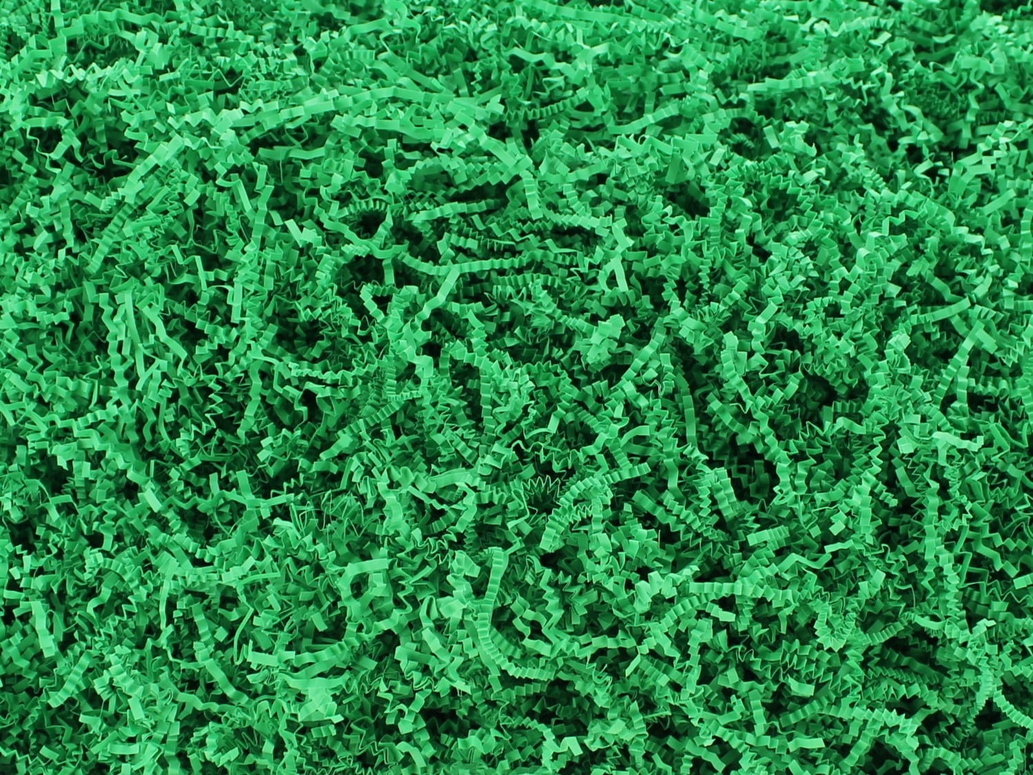 Jasnozielone, pocięte na wąskie paski wypełnienie dekoracyjne z papieru, tworzące gęstą teksturę