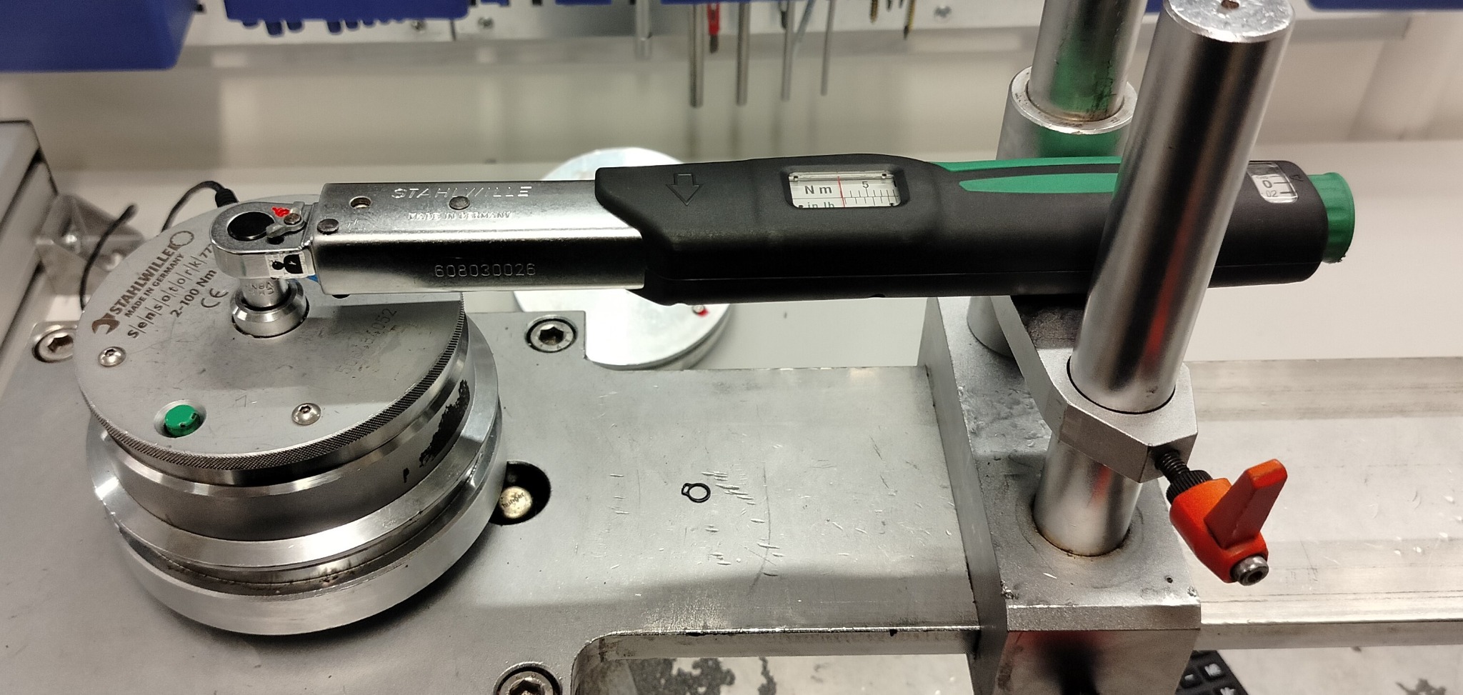 Klucz dynamometryczny Stahlwille na stanowisku pomiarowym, widoczny wyświetlacz z wartością momentu obrotowego, metalowa konstrukcja stanowiska z elementami regulacyjnymi.