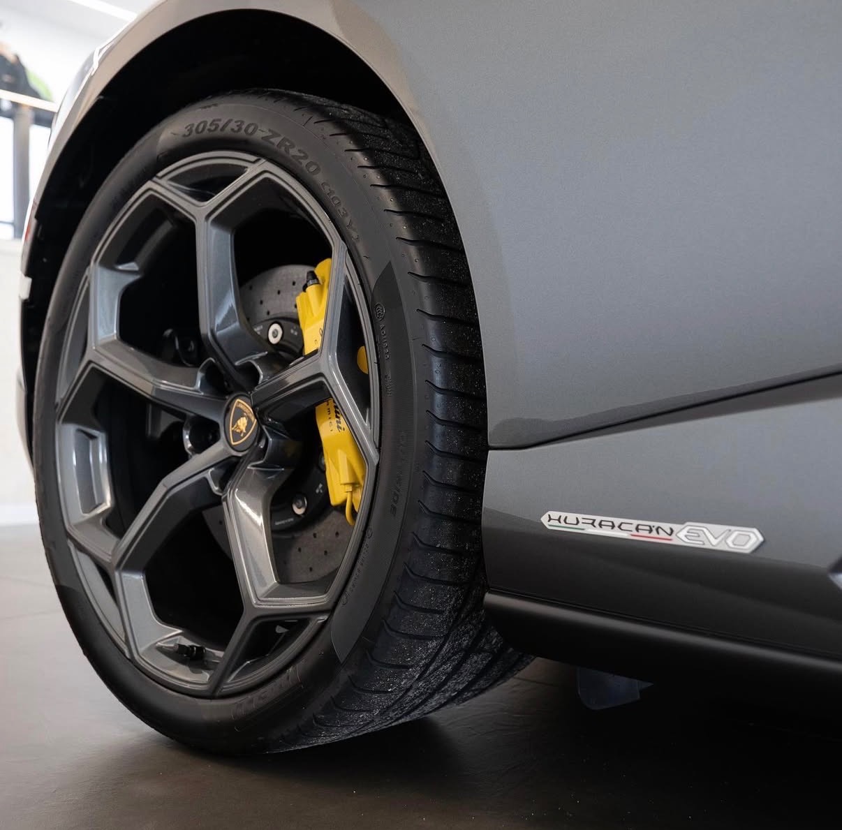 Szare Lamborghini Huracan Evo: felga z żółtymi zaciskami hamulcowymi, opona 305/30/ZR20, logo modelu na karoserii. Detailing i pielęgnacja.