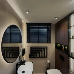 Nowoczesna łazienka w beżach z czarnymi akcentami: poziome żaluzje w oknie, owalne lustro z podświetleniem LED, umywalka nablatowa i grzejnik drabinkowy.