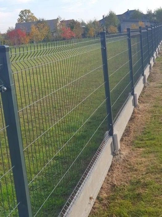 Nowoczesny montaż ogrodzenia panelowego na podmurówce betonowej w Świebodzinie. Solidne wykonanie, widok na zielony trawnik i zabudowania w tle.