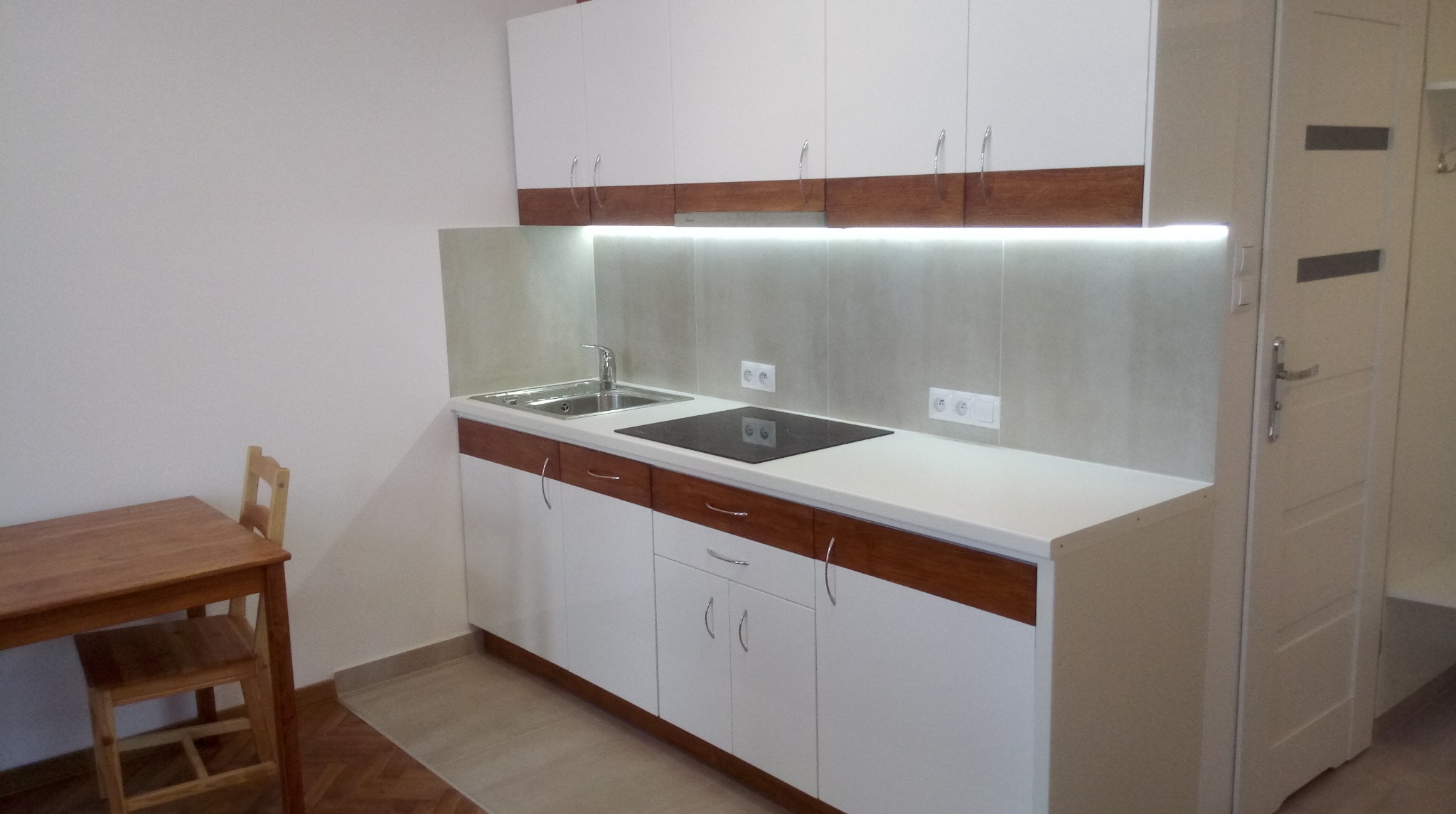 Aneks kuchenny z lakierowanych frontów z dodanymi elementami drewnianymi.