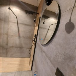 Oleksandr Turchynskyi - Nowoczesna łazienka z szarymi płytkami, deszczownicą, okrągłym lustrem z podświetleniem LED i drewnianym podestem prysznicowym.