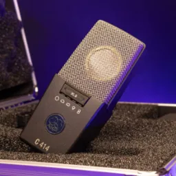 Mikrofon pojemnościowy AKG C414 XLS w twardym futerale, oświetlony fioletowym światłem, widoczne ustawienia charakterystyki kierunkowej.
