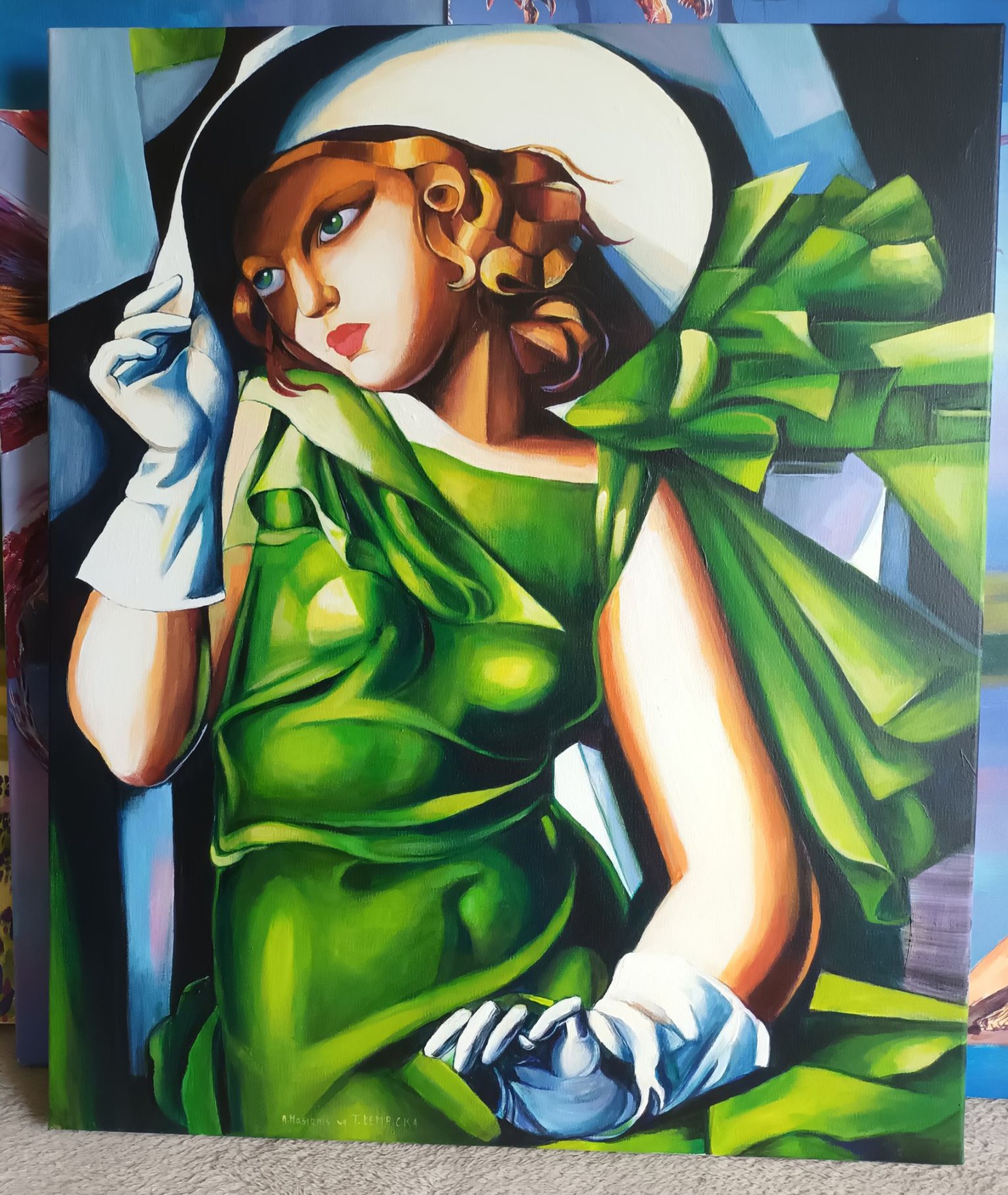 Kopia obrazu Tamary Łempickiej: portret kobiety w zielonej sukni i białym kapeluszu, namalowany farbami olejnymi na płótnie, widoczny podpis autora w lewym dolnym rogu.