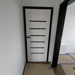 4 HOMES Wojciech Bodnar Wyposażenie i wykończenie wnętrz - VIVENTO drzwi przylgowe w kolorze białym i czarnym szkłem (barwione w masie - NIE LAKOBEL) , z czarną ościeżnicą.