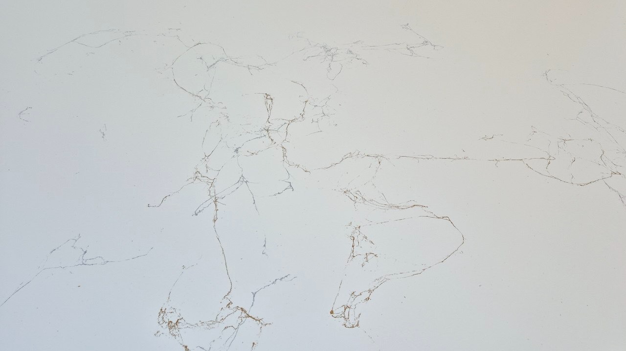 Biała powierzchnia z delikatnymi, nieregularnymi żyłkami w odcieniach szarości i złota, przypominająca marmur, z widocznymi drobnymi pęknięciami i zarysowaniami.