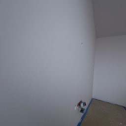 ATS Construction - Świeżo pomalowane na szaro ściany w rogu pomieszczenia z widocznymi gniazdkami elektrycznymi i zabezpieczoną podłogą. Minimalistyczne wykończenie wnętrza.