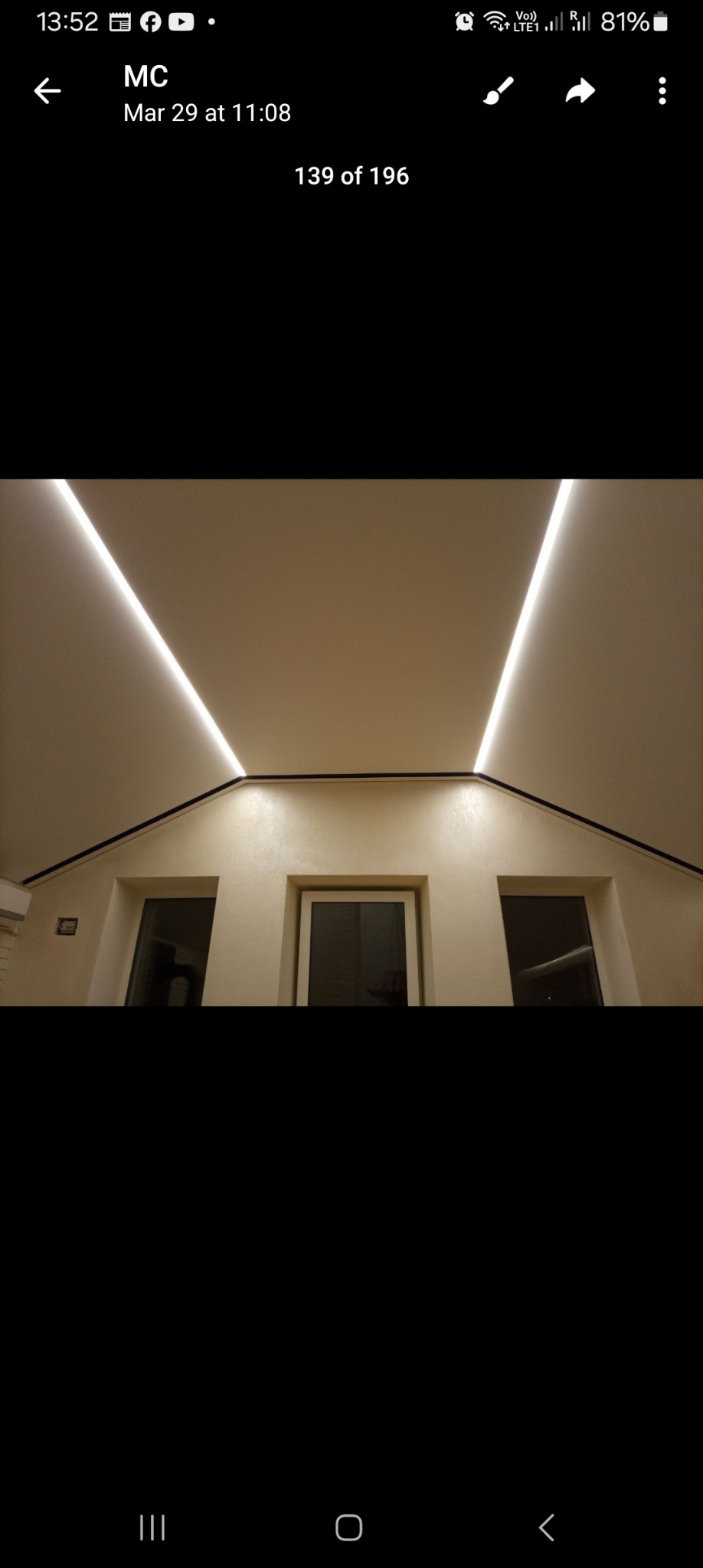 Nowoczesny pokój z oknami pod skosem i podświetlanym sufitem z ledami, wykończony w jasnych barwach, z widoczną fakturą na ścianach.