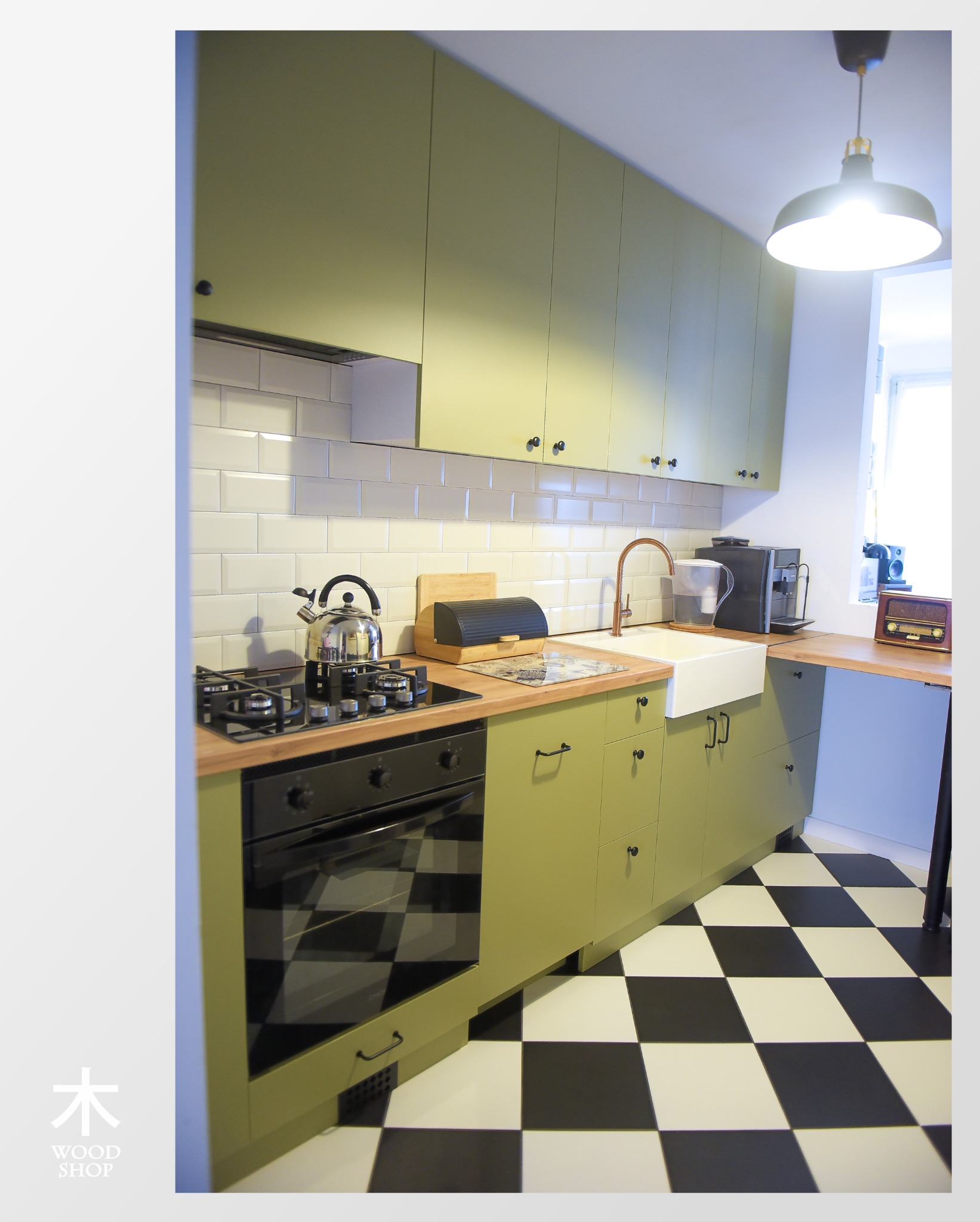 Klimatyczna kuchnia w odcieniach zieleni z czarno-białą podłogą w szachownicę. Uwagę przykuwają miedziana bateria i retro radio na blacie.