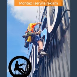 Sierra Prace Wysokościowe - Pracownik w uprzęży montuje dużą reklamę na budynku. Widoczne liny, sprzęt i fragment nieba. Dodatkowo w lewym dolnym rogu grafika sylwetki osoby na linach.