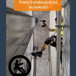 Sierra Prace Wysokościowe - Pracownik w uprzęży, wierci wiertarką w betonowej ścianie na wysokości. Widoczny fragment ściany, liny i metalowa konstrukcja. W tle grafika sylwetki pracownika.