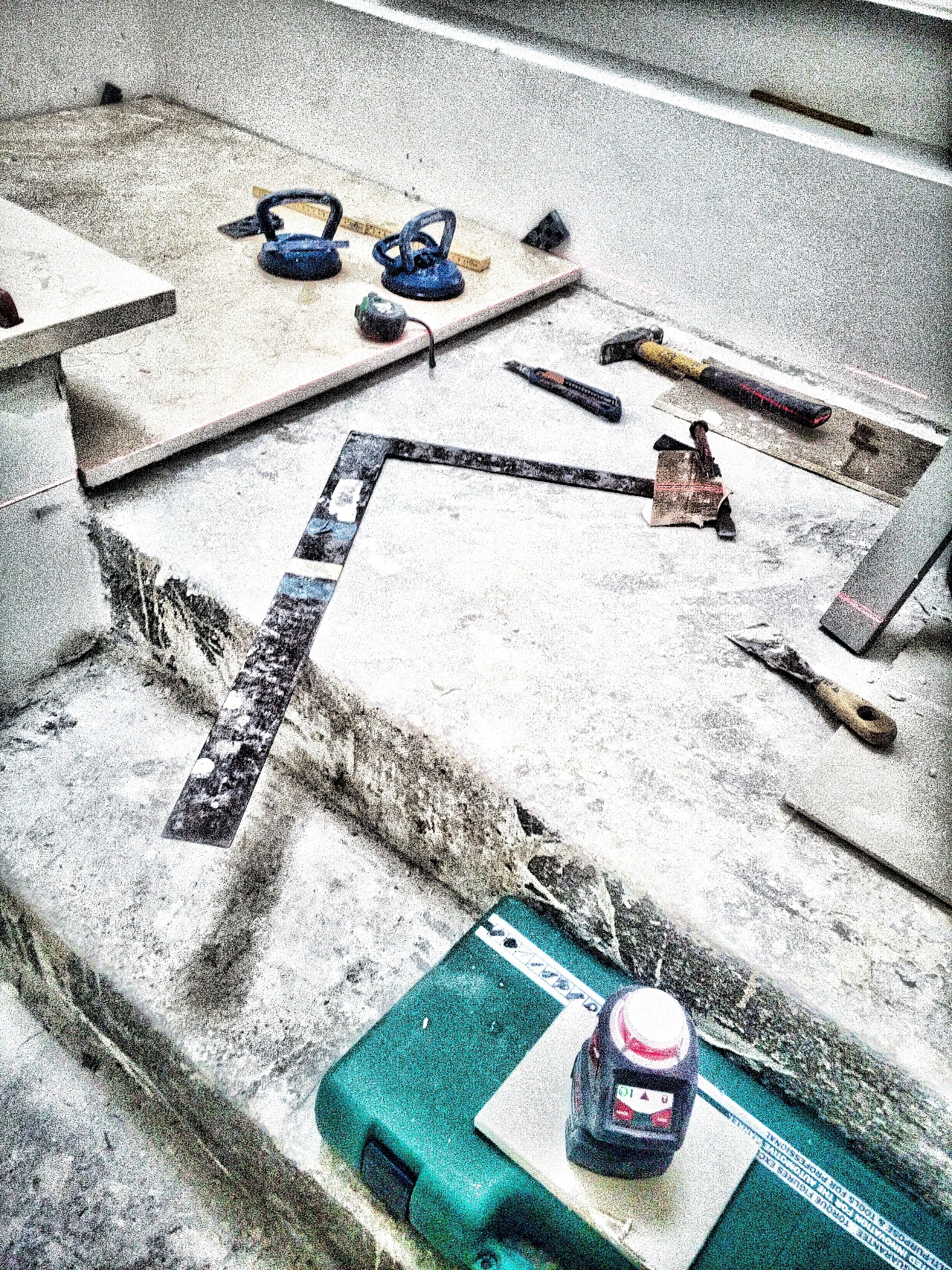 Montaż blatu kamiennego: narzędzia, poziomica laserowa, przyssawki do kamienia na powierzchni roboczej, przygotowanie do instalacji, widok z góry.