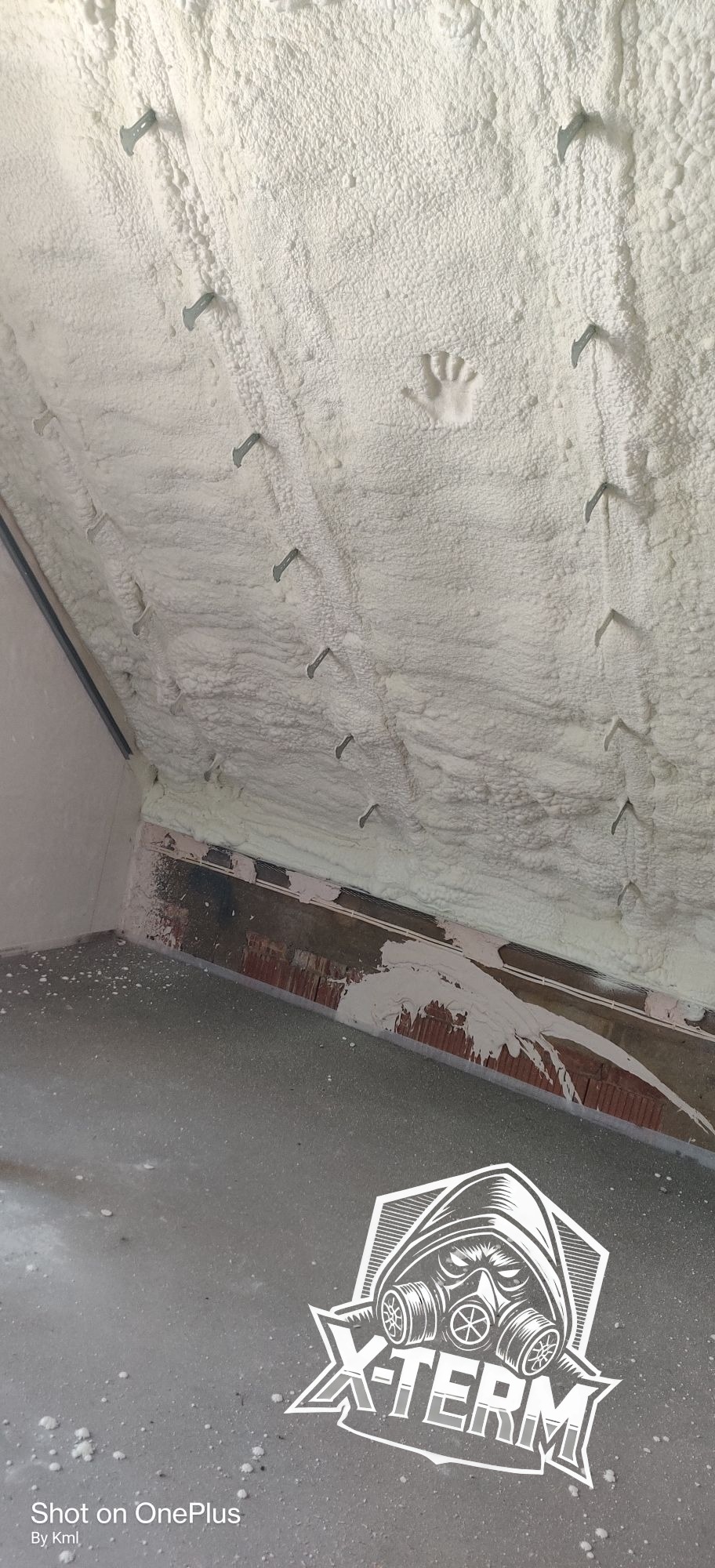 Poddasze po ociepleniu pianką PUR, widoczne metalowe mocowania i odcisk dłoni w pianie.