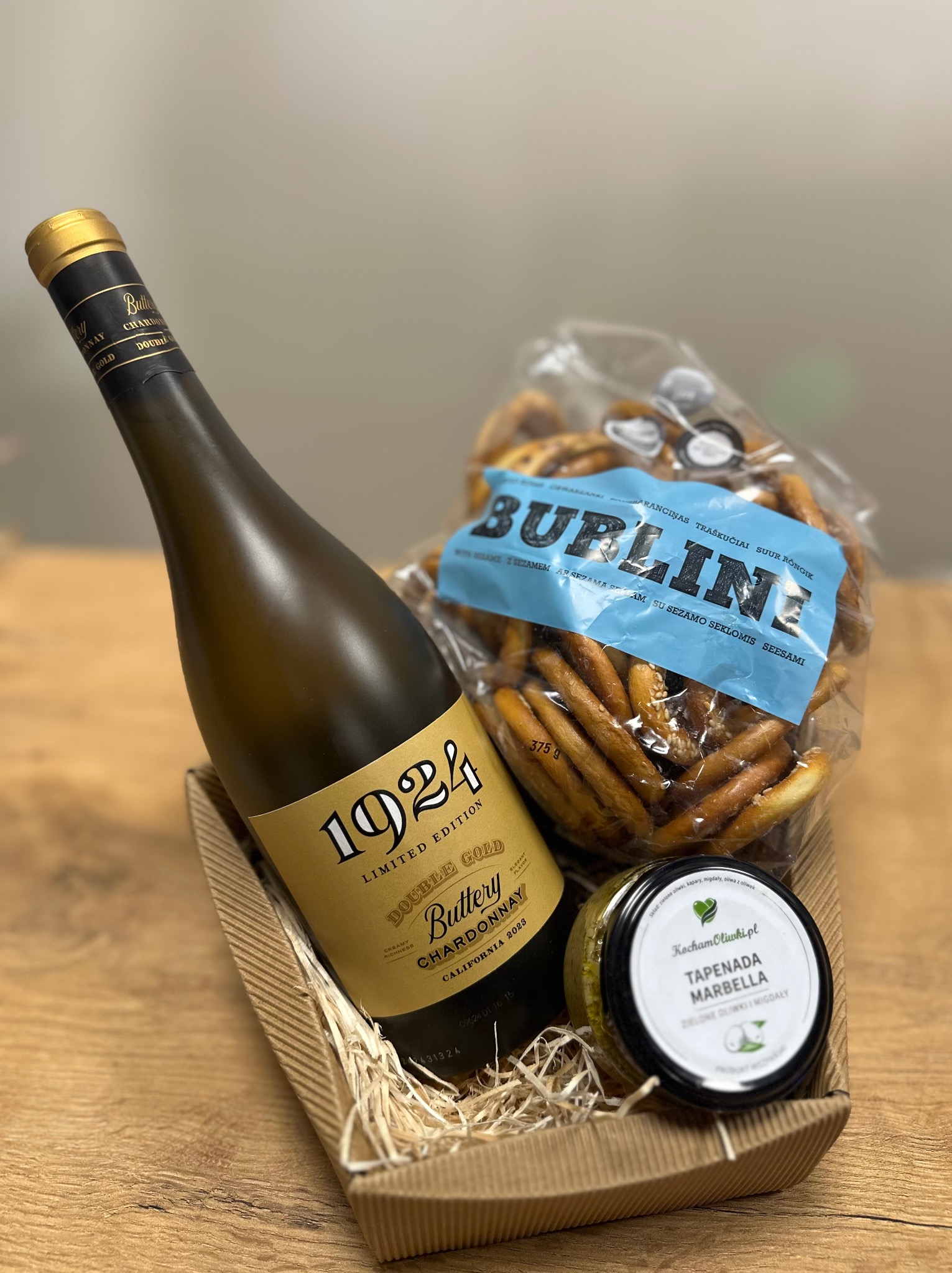 Zestaw prezentowy: butelka białego wina '1924 Buttery Chardonnay Double Gold', paczka słonych paluszków 'Burline' z sezamem i słoik tapenady z zielonych oliwek i migdałów 'Tapenada Marbella'...