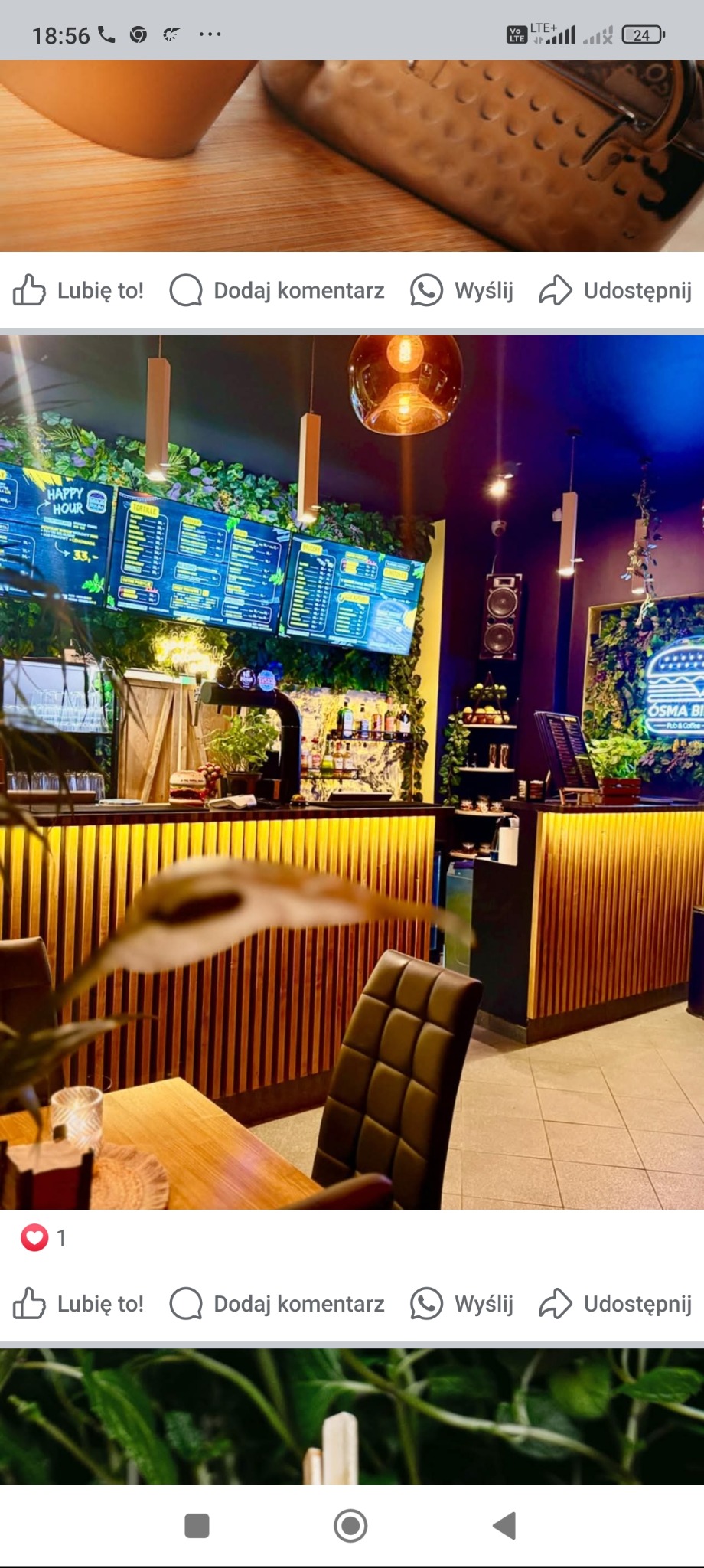 Wnętrze lokalu gastronomicznego: drewniany bar z podświetleniem, menu na ekranach, rośliny, stoliki z krzesłami. Dekoracja z wykorzystaniem elementów roślinnych.