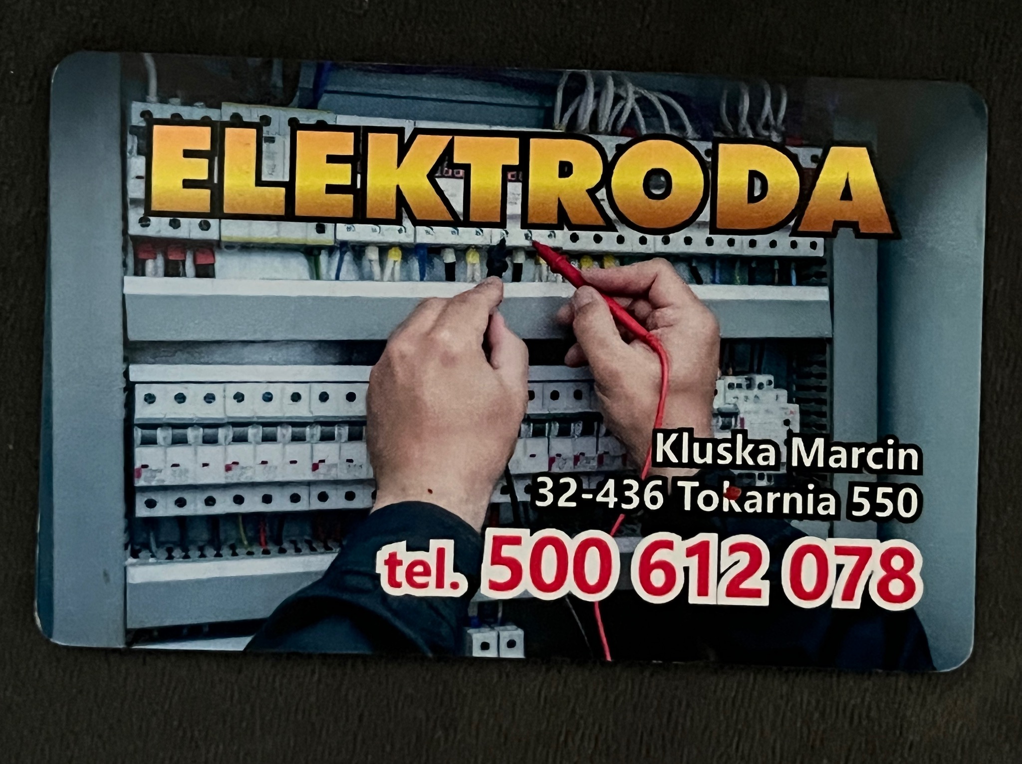 Wizytówka firmy ELEKTRODA prezentująca pomiary w skrzynce elektrycznej, z numerem telefonu 500 612 078 i adresem.