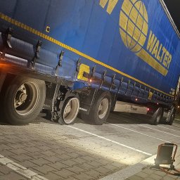 Mobilna wulkanizacja płock 24h7 Paradowski Marcin - Niebieska naczepa ciężarówki z logo WALTER i uszkodzoną oponą, stojąca na parkingu oświetlonym lampą roboczą.