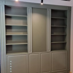 Ma&Ja Meble - Duża, grafitowa szafa wnękowa z otwartymi półkami i zamkniętymi szafkami, oświetlona dwoma reflektorami sufitowymi, na podłodze parkiet w jodełkę.