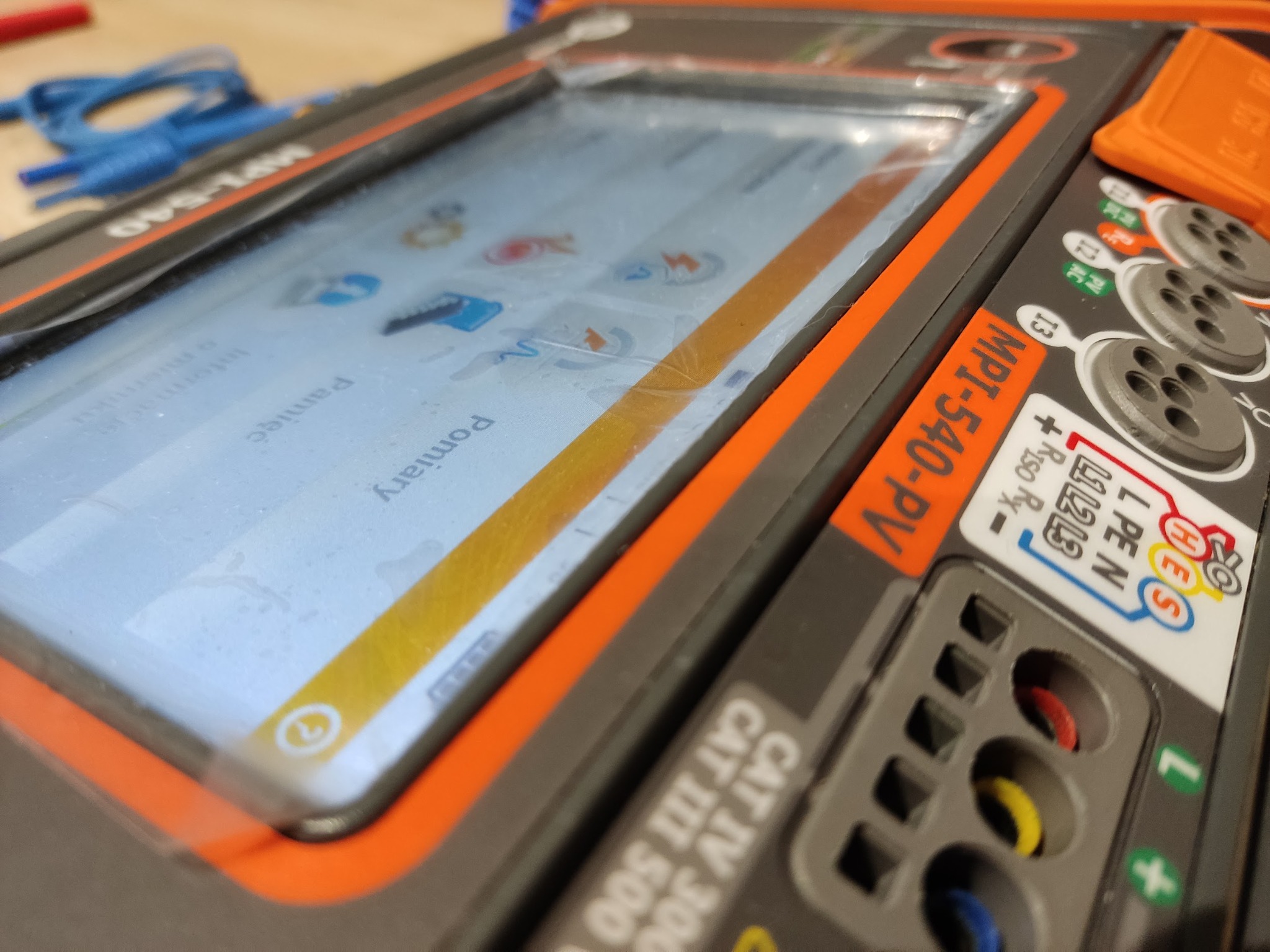 Miernik MPI-540-PV z ekranem dotykowym, wyświetlającym menu pomiarów elektrycznych. Widoczne gniazda pomiarowe i oznaczenia kategorii bezpieczeństwa CAT IV 300V.