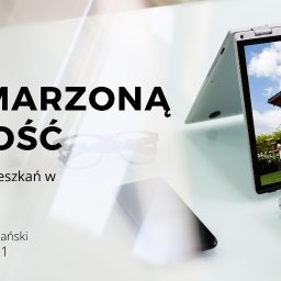 Rzeszownieruchomosci.pl - Ziemiański & Kroczek - Laptop wyświetlający zdjęcie domu z ogrodem, obok okulary i smartfon na białym biurku, widoczny tekst 'Marzonałość mieszkań w'