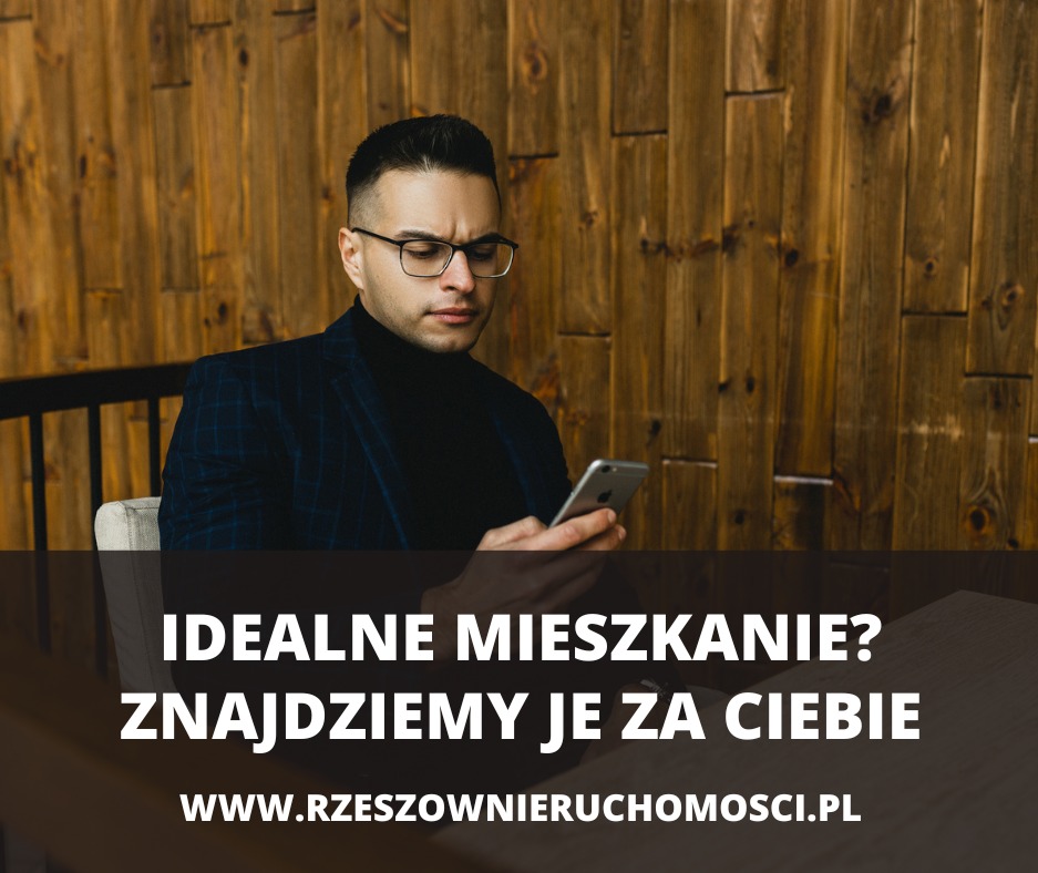 Mężczyzna w okularach i marynarce przegląda telefon komórkowy na tle drewnianej ściany z tekstem 'Idealne mieszkanie? Znajdziemy je za Ciebie. www.rzeszownieruchomosci.pl'