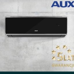 OPTIMA AGNIESZKA CZYŻYCKA - Czarny klimatyzator marki AUX zamontowany na szarej ścianie z widocznym logo i informacją o 5-letniej gwarancji.