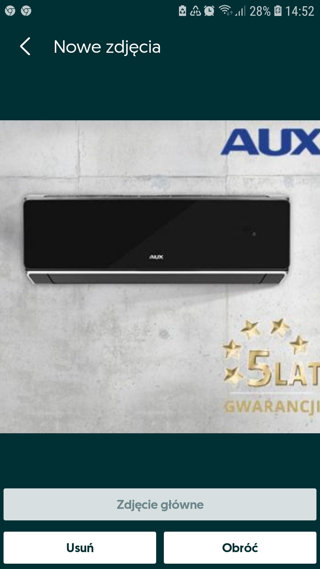 Czarny klimatyzator marki AUX zamontowany na szarej ścianie z widocznym logo i informacją o 5-letniej gwarancji.