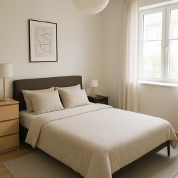 LAKU SPÓŁKA Z OGRANICZONĄ ODPOWIEDZIALNOŚCIĄ - Jasna sypialnia z łóżkiem z szarym zagłówkiem, beżową pościelą i okrągłą lampą w stylu japońskim, uzupełniona o minimalistyczny obraz na ścianie i drewnianą komodę.