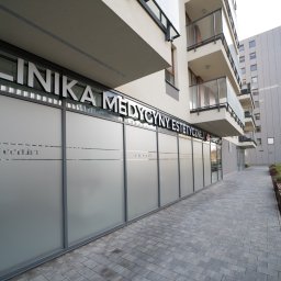 ROBERT JANCZURA PERFECTLIFT - Fasada nowoczesnej kliniki medycyny estetycznej z napisem 'KLINIKA MEDYCYNY ESTETYCZNEJ' nad matowymi oknami i nazwą 'Perfect Lift' na szklanych panelach, widok z chodnika.