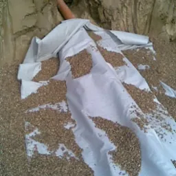 Instalacja drenażu rozsączającego oczyszczalni ścieków IN-DRAN w wykopie, widoczna rura drenażowa, geowłóknina i warstwa żwiru.