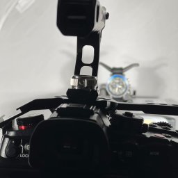Moorea Studio Mariusz Świerżewski - Czarny aparat z mikrofonem i lampą błyskową w tle, ustawiony w studiu fotograficznym. Widoczne detale mocowania i ustawienia sprzętu.
