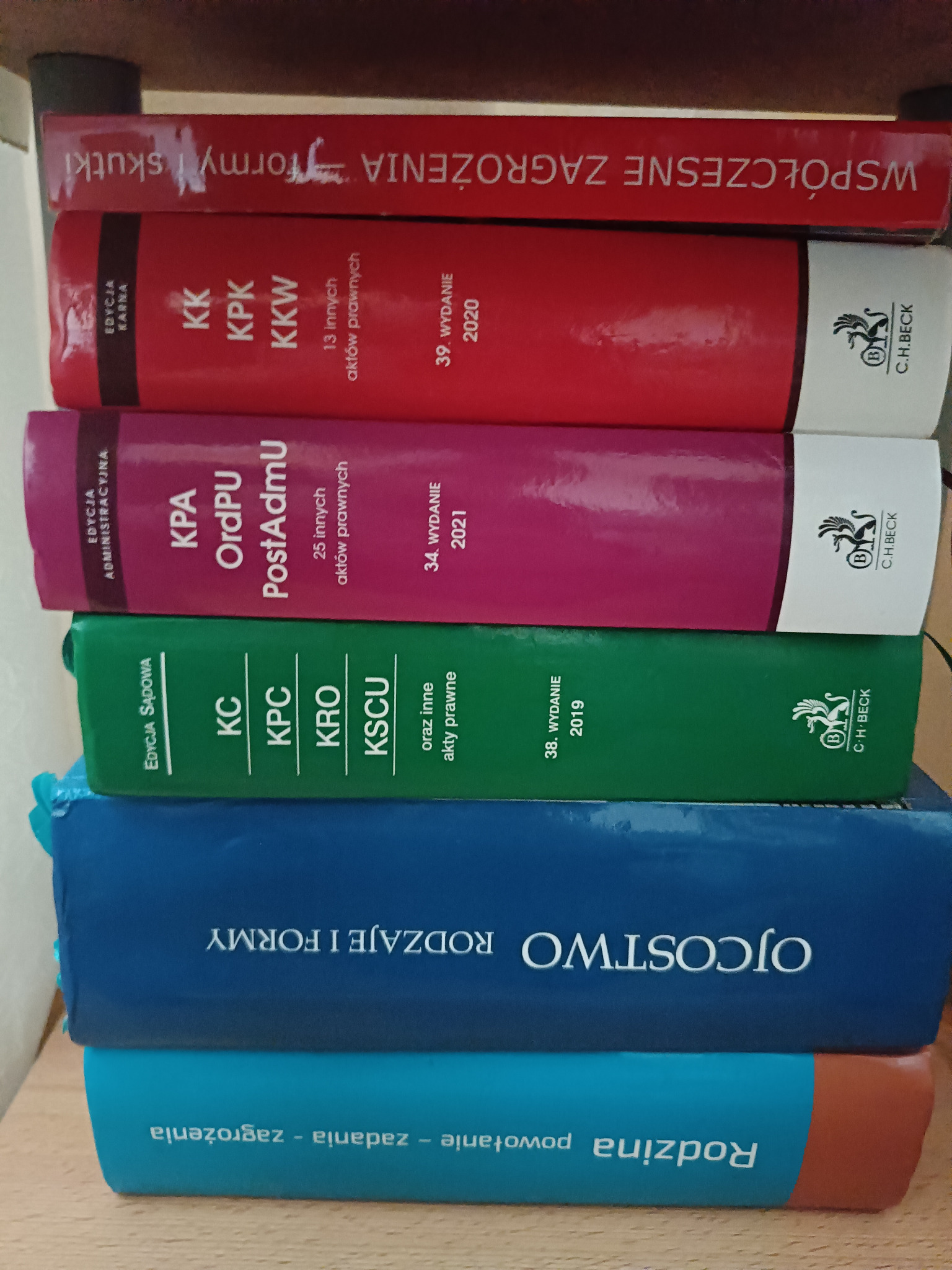 Stos prawniczych kodeksów i zbiorów aktów prawnych, w tym kodeks karny, postępowania karnego, cywilny, rodzinny i opiekuńczy, ułożonych jeden na drugim.