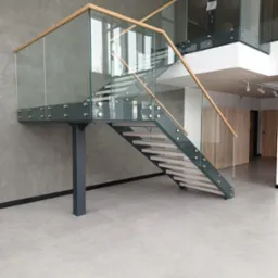 Schody wewnętrzne. Stal czarna lakierowana, stopnie z kamienia. Balustrada szkło plus pochwyt drewno.