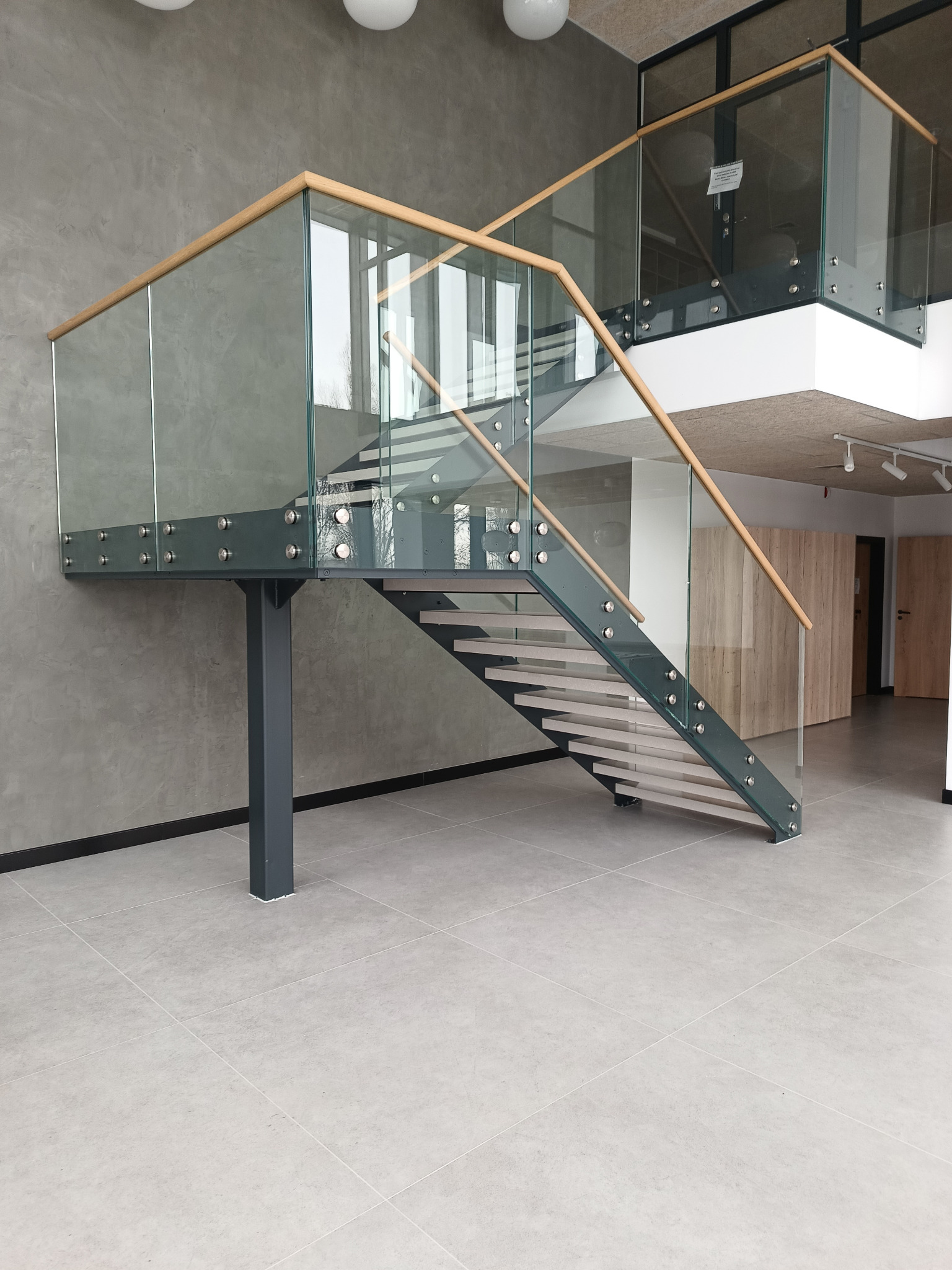 Schody wewnętrzne. Stal czarna lakierowana, stopnie z kamienia. Balustrada szkło plus pochwyt drewno.