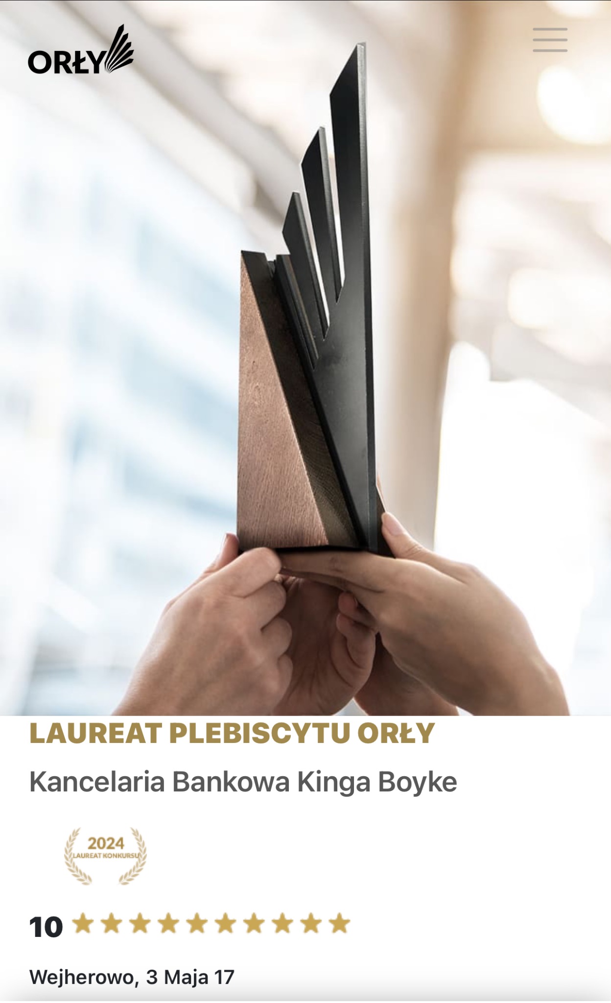 Wręczenie nagrody 'Orły' dla Kancelarii Bankowej Kinga Boyke; statuetka w dłoniach na rozmytym tle biurowca. Laureat Plebiscytu Orły 2024.