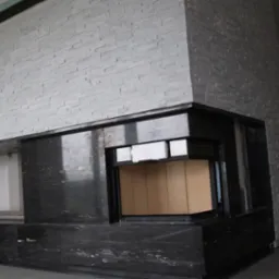 Nowoczesny kominek z obudową z czarnego kamienia i ściana wykończona płytkami imitującymi kamień w odcieniach szarości, widoczne elementy wkładu kominkowego.