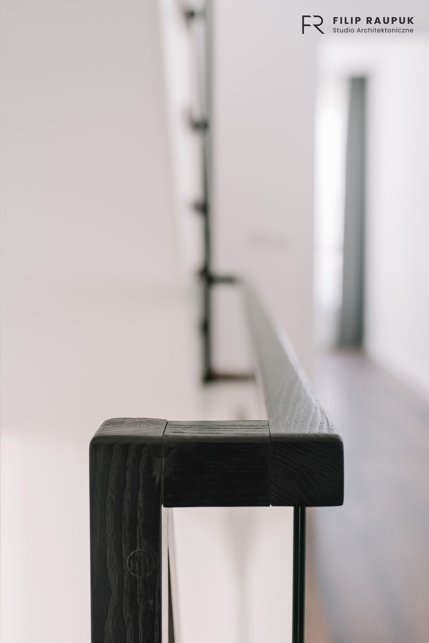 Detal nowoczesnej balustrady schodowej z ciemnego drewna i szkła, minimalistyczny design, jasne wnętrze, neutralne tło,  widok z bliska na fragment poręczy.