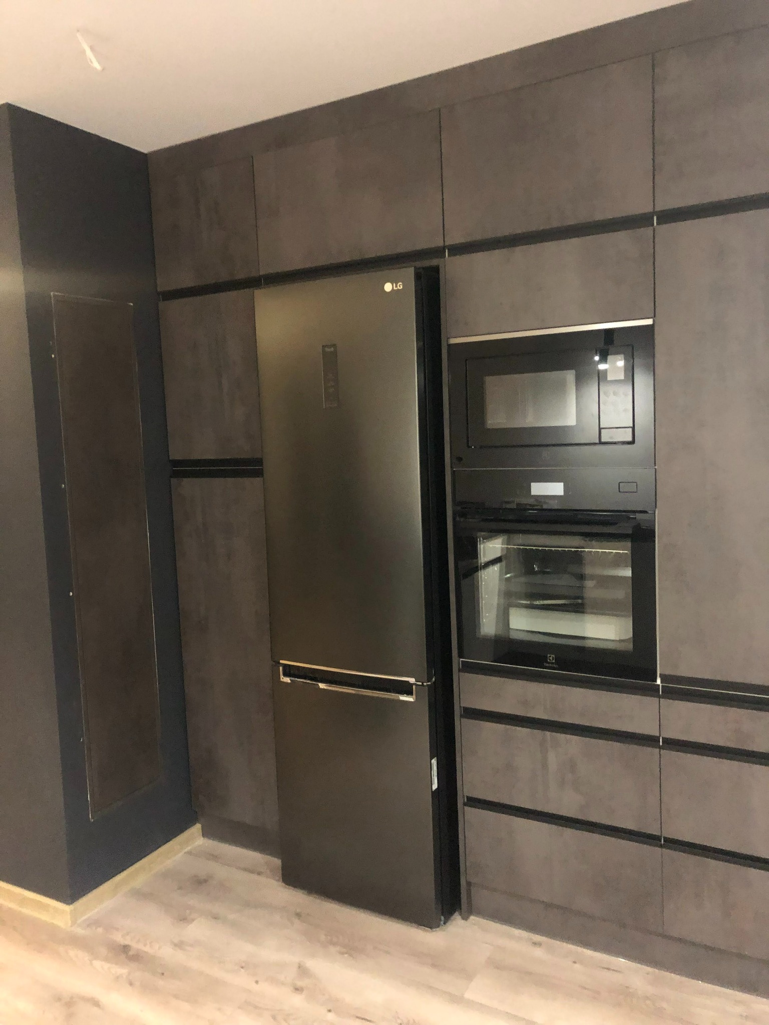 Nowoczesna, szara kuchnia z zabudową na wymiar, zintegrowana lodówka LG i piekarnik Electrolux, minimalistyczny design.