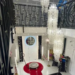 Widok z góry na przygotowaną strefę z obrotową platformą 360° na czerwonym dywanie, oświetloną lampami LED i girlandami świetlnymi, dekorowaną wiszącymi żyrandolami z muszelek.