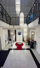 Elegancka przestrzeń z trzema kryształowymi żyrandolami, czerwonym dywanem i dekoracjami świetlnymi, widok z góry.