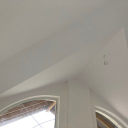 Ma-dom - Pomalowane na biało poddasze z oknami łukowymi, widoczne kable wystające z sufitu, świeżo po malowaniu.