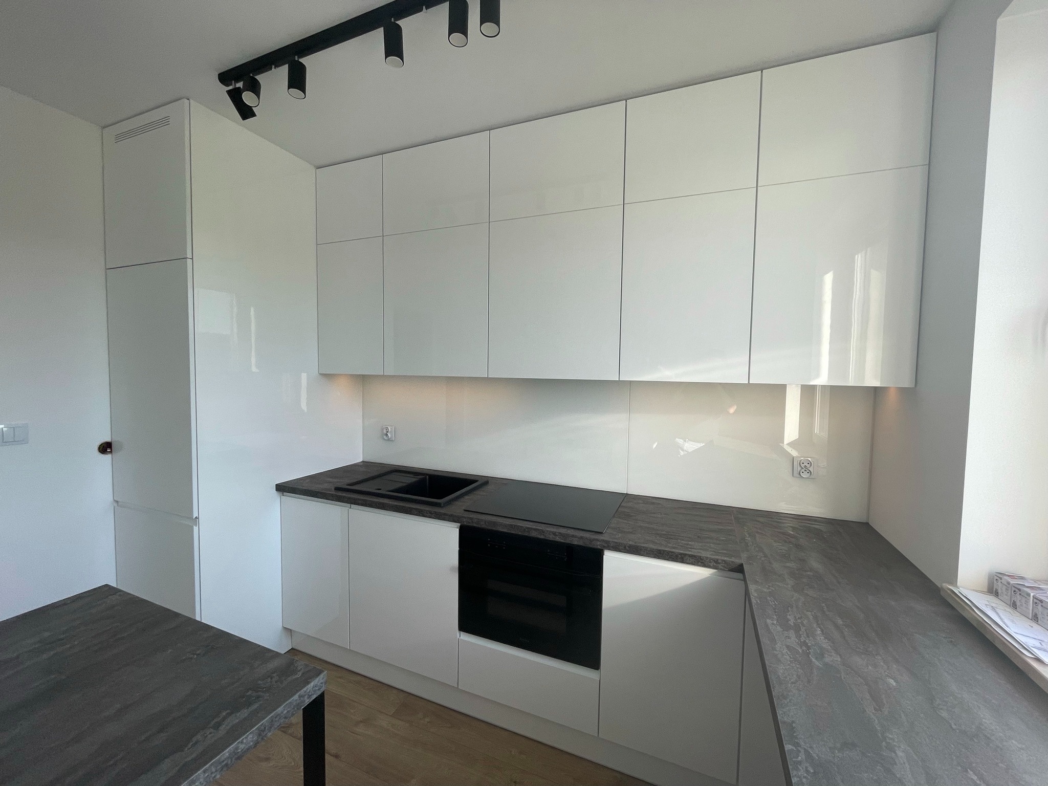 Kuchnia w białym połysku oraz blatem z płyty laminowanej